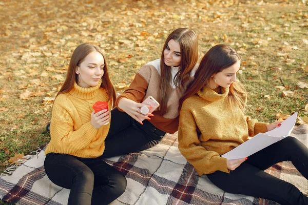 Dívky sedící na dece v podzimním parku — Stock fotografie