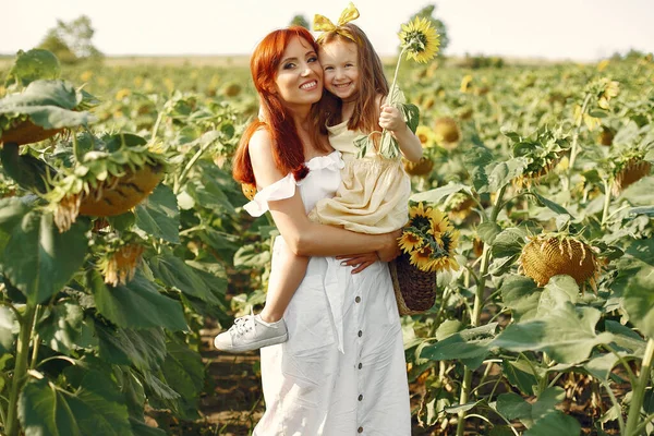 Mooi en schattig gezin in een veld met zonnebloemen — Stockfoto