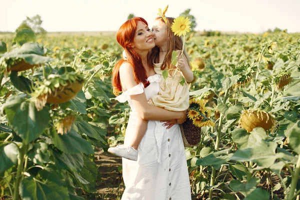 Mooi en schattig gezin in een veld met zonnebloemen — Stockfoto