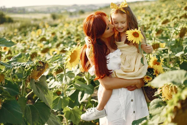 Mooi en schattig gezin in een veld met zonnebloemen — Stockfoto