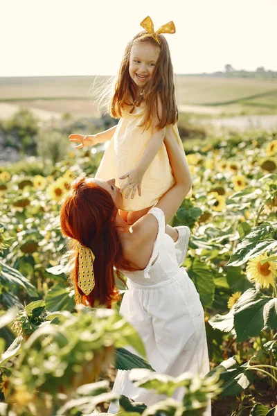 Mooi en schattig gezin in een veld met zonnebloemen — Stockfoto