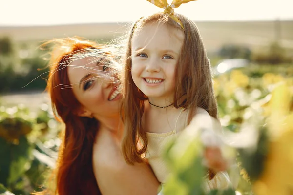 Mooi en schattig gezin in een veld met zonnebloemen — Stockfoto