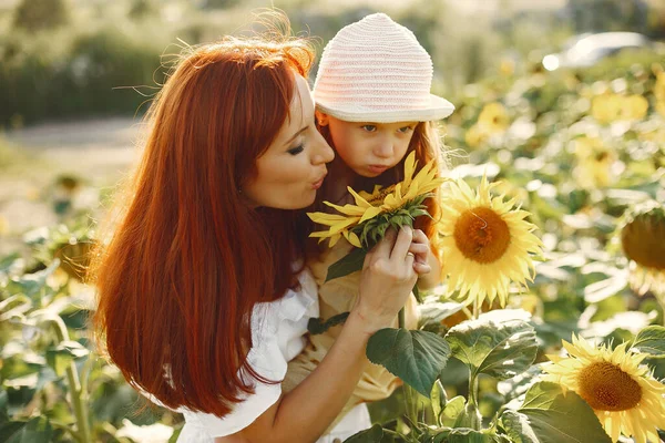 Mooi en schattig gezin in een veld met zonnebloemen — Stockfoto