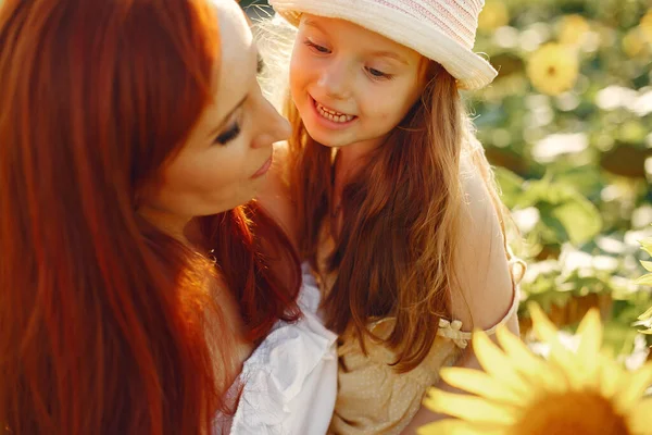 Mooi en schattig gezin in een veld met zonnebloemen — Stockfoto