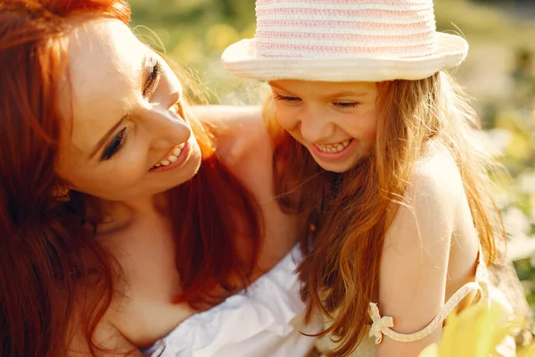 Mooi en schattig gezin in een veld met zonnebloemen — Stockfoto