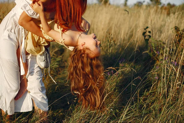 Mor med dotter som leker på ett sommarfält — Stockfoto