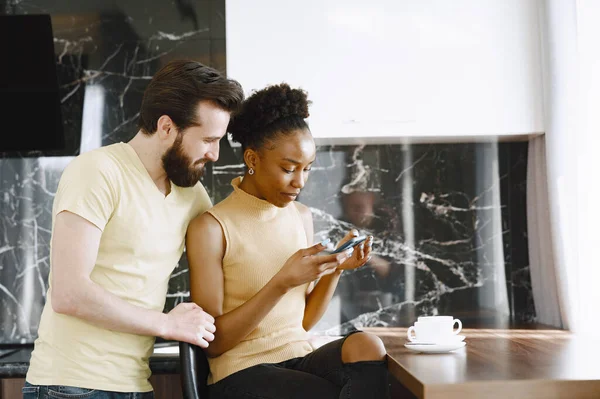 Par multirracial na cozinha abertura em um smartphone — Fotografia de Stock