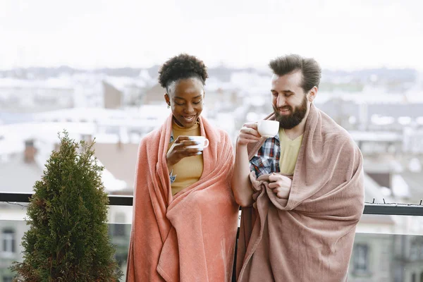 Bir adam ve bir kadın terasta battaniyede kahve içiyorlar. — Stok fotoğraf