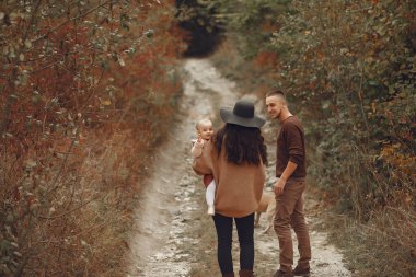 Sonbahar tarlasında oynayan sevimli ve şık bir aile.