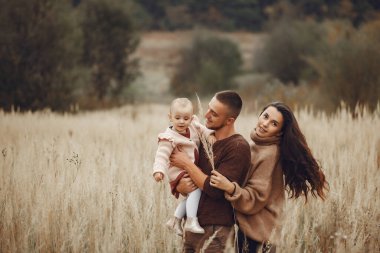 Sonbahar tarlasında oynayan sevimli ve şık bir aile.