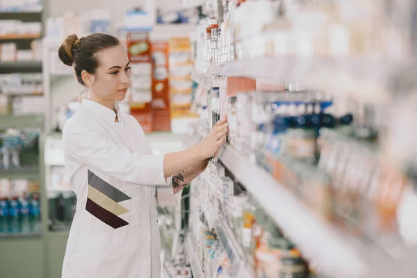 Женщина-фармацевт проверяет лекарства в аптеке — стоковое фото
