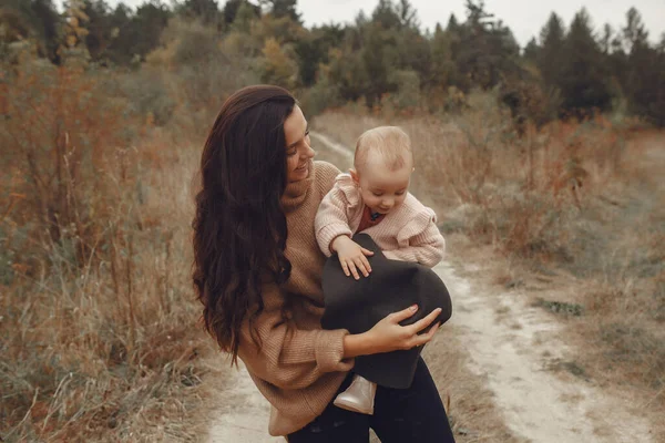 Mor med liten dotter som leker på ett höstfält — Stockfoto