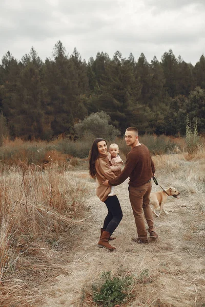 Linda y elegante familia jugando en un campo de otoño — Foto de Stock