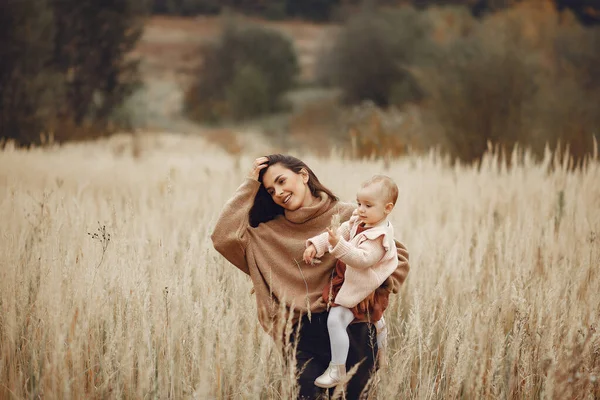 Mutter mit kleiner Tochter spielt auf einem Feld im Herbst — Stockfoto