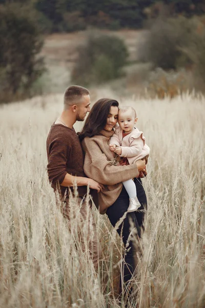 Nette und stylische Familie spielt in einem herbstlichen Feld — Stockfoto