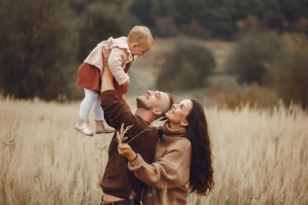 Linda y elegante familia jugando en un campo de otoño — Foto de Stock