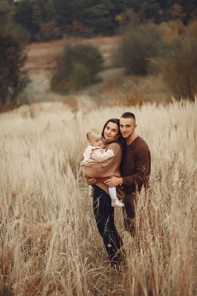 Linda y elegante familia jugando en un campo de otoño — Foto de Stock