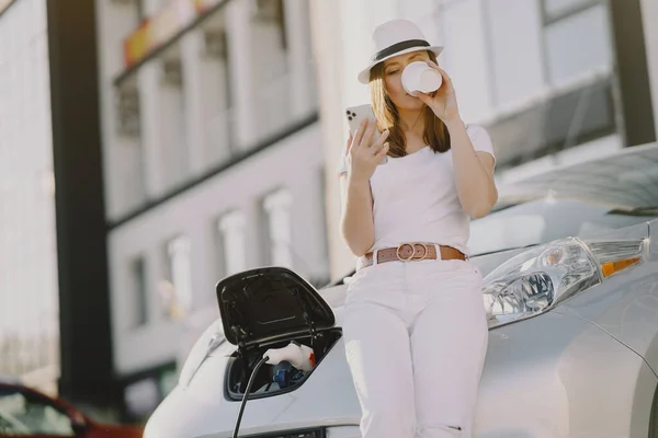 Žena nabíjení elektro auto na elektrické čerpací stanici — Stock fotografie