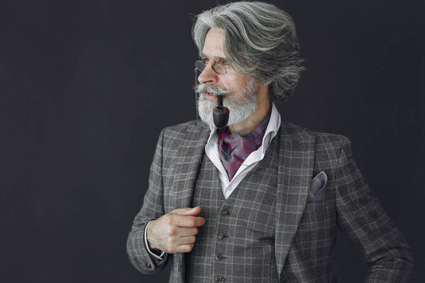 Elegant senior man with a smoking pipe