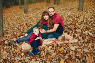 Sonbahar parkında küçük oğlu olan bir aile.