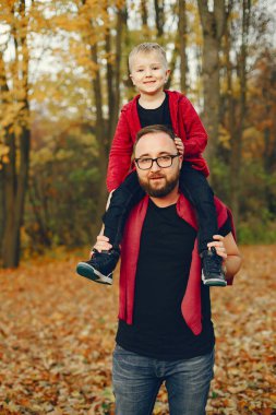 Sonbahar parkında oynayan sevimli bir aile.