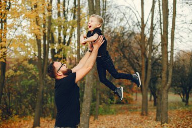 Sonbahar parkında oynayan sevimli bir aile.