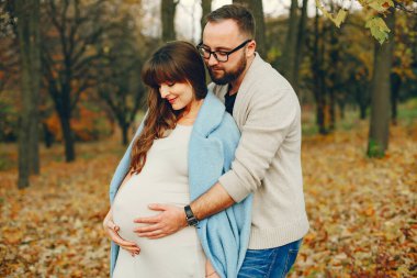 Zarif çift sonbahar parkında vakit geçiriyor.