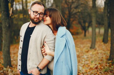 Zarif çift sonbahar parkında vakit geçiriyor.