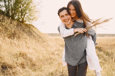 Gün batımında buğday tarlasında aşık mutlu çift