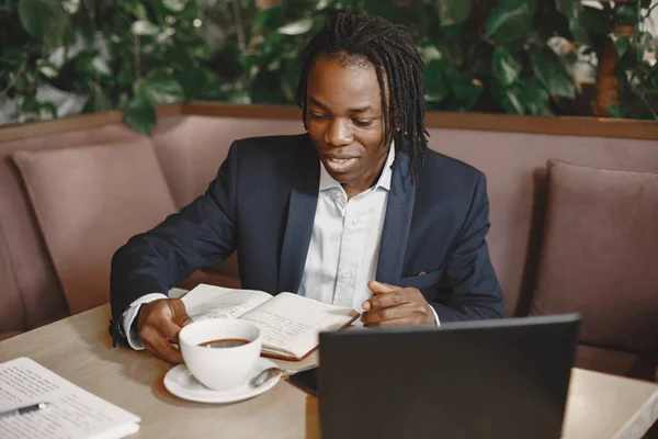 Bonito homem africano num fato preto num café — Fotografia de Stock