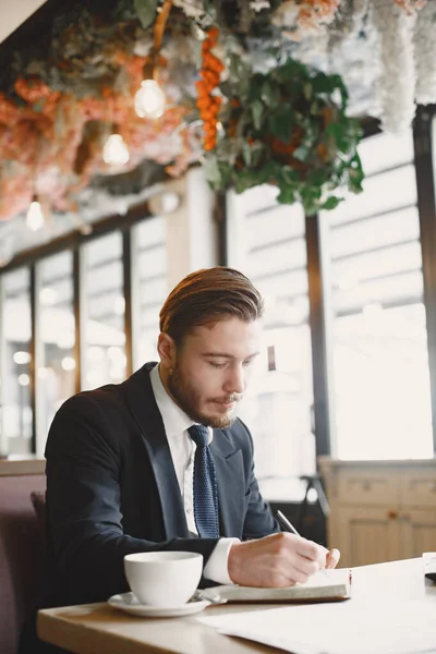 Homme assis avec ordinateur portable dans un café — Photo