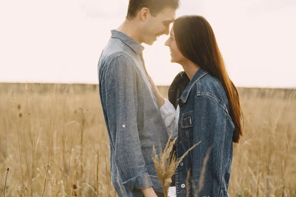 Feliz casal apaixonado no campo de trigo ao pôr-do-sol — Fotografia de Stock
