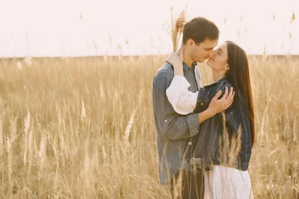 Feliz casal apaixonado no campo de trigo ao pôr-do-sol — Fotografia de Stock