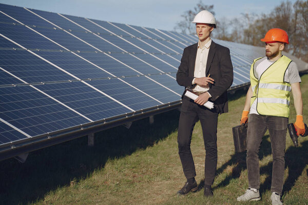 Форман и бизнесмен на солнечной электростанции.