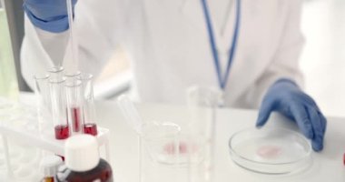 Laboratuvar çalışanı kan örneklerini inceleyerek patolojileri tespit ediyor.