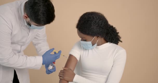 Médico em equipamento de proteção individual vacinando um paciente — Vídeo de Stock