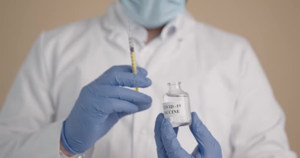 Medische medewerker die vaccinoplossing met spuit inneemt — Stockvideo