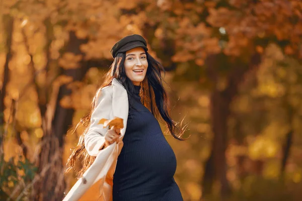 Femeie gravidă într-o haină maro într-un parc de toamnă — Fotografie, imagine de stoc