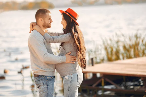 Zwangere vrouw met haar man in de buurt van de rivier — Stockfoto