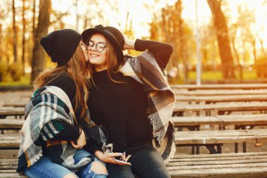 Sonbahar şehrinde iki genç kız şehirde dolaşıp park ediyor.