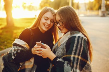 Sonbahar şehrinde iki genç kız şehirde dolaşıp park ediyor.