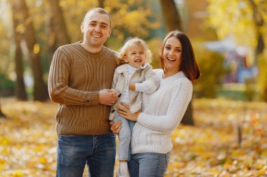 Sonbahar tarlasında oynayan sevimli ve şık bir aile.