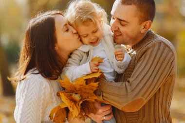 Sonbahar tarlasında oynayan sevimli ve şık bir aile.