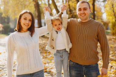 Sonbahar tarlasında oynayan sevimli ve şık bir aile.