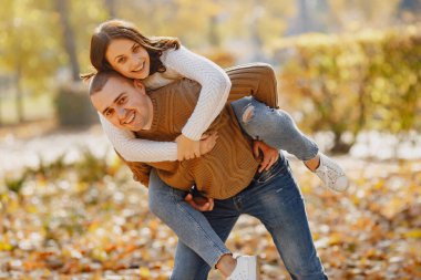 Güzel bir çift sonbahar parkında vakit geçirir.