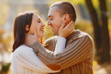 Güzel bir çift sonbahar parkında vakit geçirir.