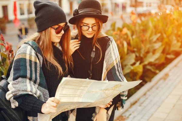 Two young girls walk around the city in the autumn city and park — стоковое фото