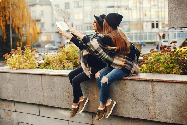 Twee jonge meisjes lopen rond de stad in de herfst stad en park — Stockfoto