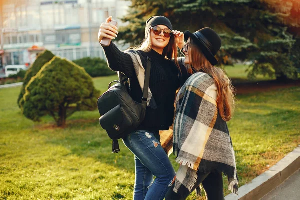 Zwei junge Mädchen spazieren durch die Stadt in der Herbststadt und parken — Stockfoto