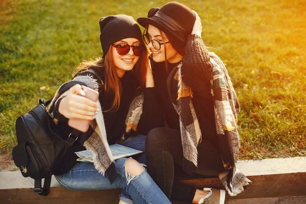 Dos jóvenes caminan por la ciudad en la ciudad de otoño y el parque —  Fotos de Stock